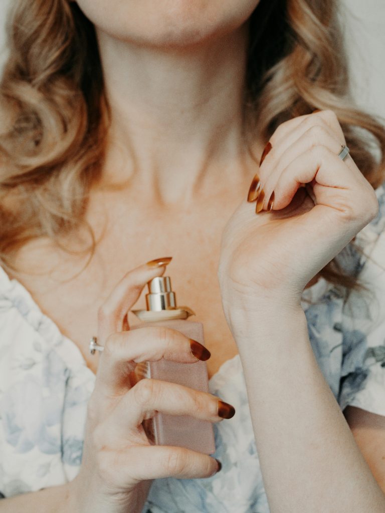cosmetic fragrance: woman spraying perfume on her wrist